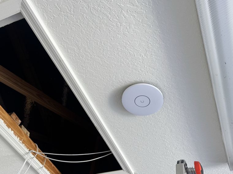Wireless access point installed near a ceiling access opening.