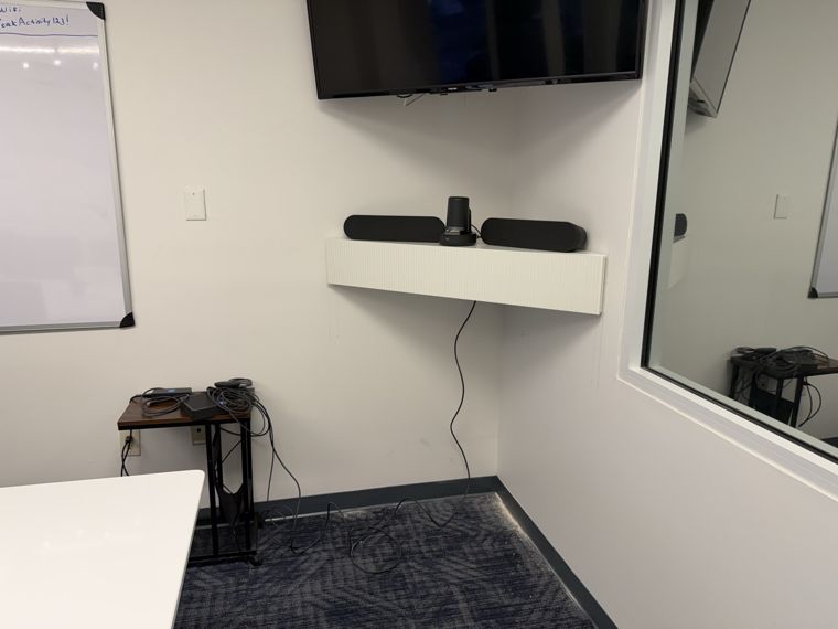 Wall display and conferencing equipment installed in a meeting room.