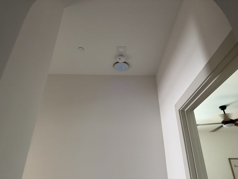 Wireless access point mounted above a hallway doorway.